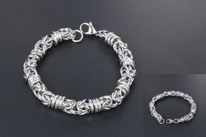 Detailed macro view of silver Byzantine chain weave and lobster clasp for men's steel bracelet