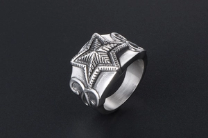 Macro shot of silver pentagram star ring with vintage industrial embossed patterns