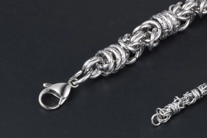 Detail of silver titanium steel woven chain bracelet featuring a lobster clasp closure