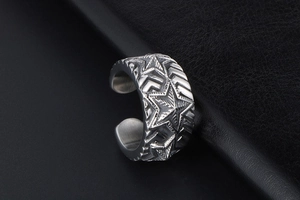 Macro shot of vintage stainless steel ring featuring five-pointed star carvings and texture