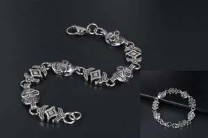 Detailed view of silver-gray skull and geometric link bracelet with lobster clasp