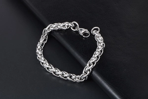 Vue détaillée du bracelet gourmette en titane argenté avec fermoir sur cuir noir