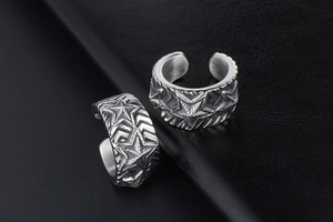 Detailed view of vintage silver steel ear cuffs with embossed stars and geometric patterns