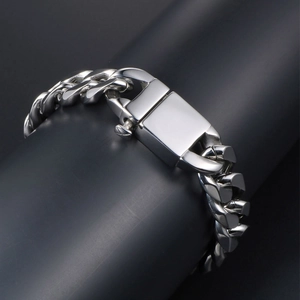 Rugged silver steel Cuban link bracelet with rectangle box clasp on dark display stand