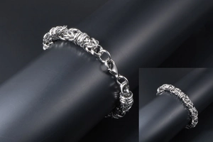 Macro detail of silver stainless steel braided chain bracelet with lobster clasp