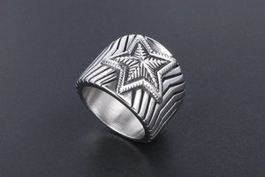 Gros plan d'une bague en acier inoxydable avec étoile en relief et gravures géométriques