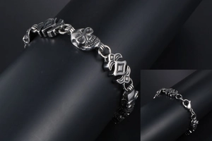 Detail of gothic skull link chain bracelet in polished stainless steel with lobster clasp
