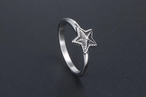 Détail d'une bague en acier inoxydable avec étoile en relief et finition argentée polie