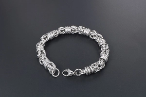 Detail of silver Byzantine weave titanium steel bracelet featuring a secure lobster clasp