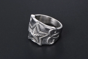 Macro view of silver star embossed ring with gothic letter engraving and punk style
