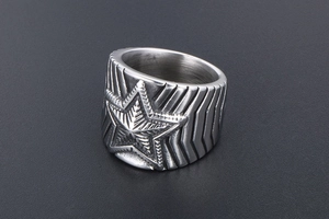 Vue macro d'une bague homme en acier avec relief d'étoile texturé et style punk rock