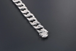 Détail d'un bracelet gourmette argenté poli avec fermoir métallique robuste pour hommes
