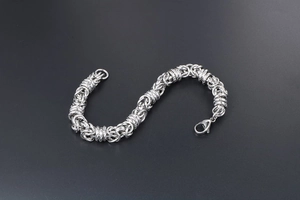 Detail of silver titanium steel woven chain bracelet with secure lobster clasp closure