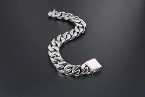 Détail d'un bracelet gourmette en acier inoxydable poli avec un fermoir carré robuste