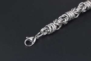 Detail of silver stainless steel woven chain bracelet with a secure lobster clasp