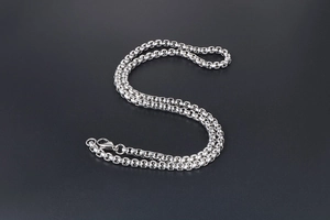 Macro shot of silver titanium steel box chain with a polished lobster clasp closure