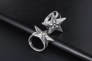 Macro shot of two vintage stainless steel rings featuring a bold 3D star design on black leather