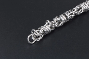 Macro shot of silver titanium steel men's bracelet with intricate mechanical weave details