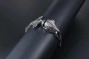 Gros plan du bracelet crocodile argenté avec texture d'écailles sur un support