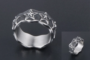 Detail of vintage star ring with distressed finish and wave edges in titanium steel
