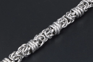 Macro view of silver stainless steel Byzantine chain link with classic woven pattern