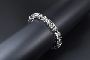 Close-up of polished silver stainless steel Byzantine woven chain bracelet for men
