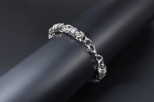 Detail of silver stainless steel braided chain bracelet with lobster clasp closure