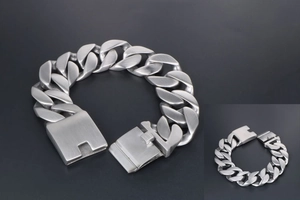 Détail macro du bracelet à maillons plats en acier titane brossé mat avec fermoir carré