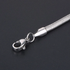 Silver snake chain necklace with lobster clasp closure on a textured black background