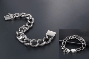 Macro shot of silver hip hop chain link bracelet with vintage engraved totem patterns