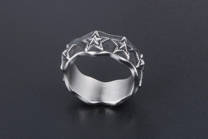 Macro shot of retro star embossed ring with wavy edges and brushed steel texture