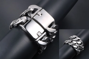 Détail macro du fermoir poli et brossé sur un bracelet gourmette épais en acier