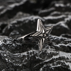 Retro oversized star titanium steel ring for men on a textured black rock background