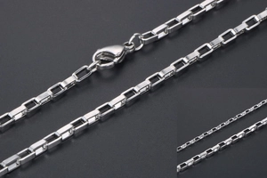 Détail macro d'un collier chaîne box en acier argenté avec fermoir mousqueton sécurisé