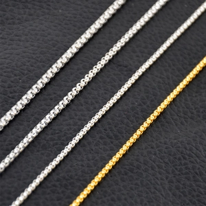 Men's titanium steel box chains in gold and silver finish on black leather background