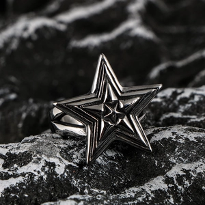 Retro oversized pentagram star ring in vintage stainless steel on a dark stone background