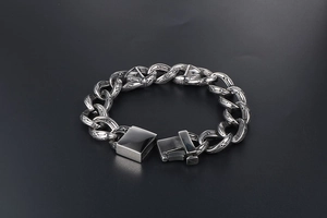Macro view of textured titanium steel links with vintage patterns on punk chain bracelet