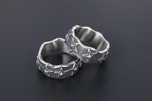 Close-up of vintage steel rings with embossed stars and unique wavy edges