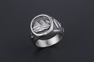 Detailed side view of vintage silver signet ring with pyramid and wave embossed design
