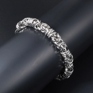 Men's silver titanium steel Byzantine chain bracelet on a black display stand