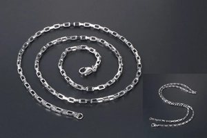 Détail macro d'une chaîne maille vénitienne en acier argenté avec fermoir mousqueton