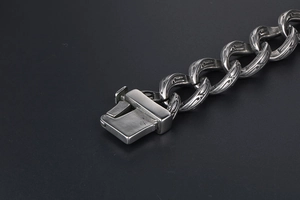 Macro detail of vintage engraved Cuban link chain bracelet with a heavy box clasp