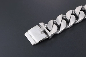 Gros plan d'un bracelet gourmette en acier titane brossé avec fermoir rectangulaire