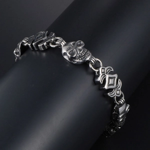 Men's gothic punk skull bracelet in silver stainless steel on a dark display stand