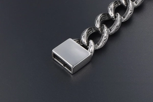 Close-up of vintage steel chain bracelet featuring detailed floral engraving and square clasp