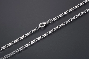 Détail macro d'un collier chaîne box en argent poli avec un fermoir mousqueton solide