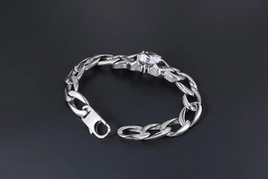 Detailed macro of silver-colored Cuban link bracelet with sparkling cubic zirconia stone