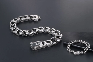 Macro detail of silver titanium steel Cuban chain bracelet with vintage pattern engraving