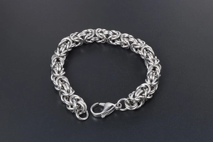 Detailed close-up of a silver Byzantine chain bracelet with a secure lobster clasp