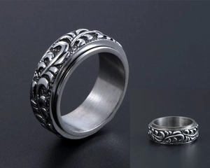 Détail d'une bague tournante vintage avec motifs floraux en relief en acier inoxydable
